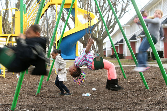 Kiah Anderson, 4, (center) waits for someone to push her on the swings at one of the playgrounds at Garden Square Apartments on Saturday, February 27, 2016. (Kelly Lafferty Gerber | Kokomo Tribune)