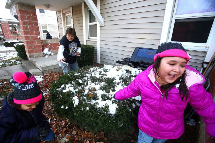 Garden Square residents Yanette and Maria Ayala have a snowball fight with their aunt Bobby Thieke on Nov. 24, 2015. (Tim Bath | Kokomo Tribune)